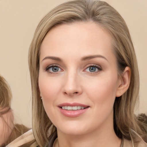 Joyful white young-adult female with long  brown hair and blue eyes