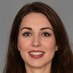 Joyful white young-adult female with long  brown hair and brown eyes