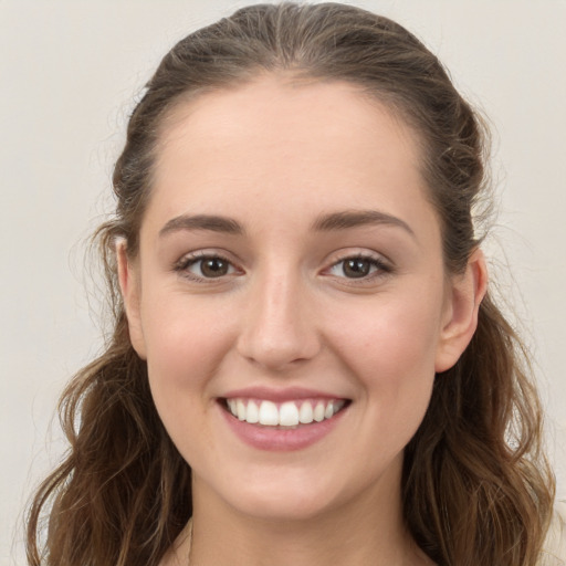 Joyful white young-adult female with long  brown hair and grey eyes