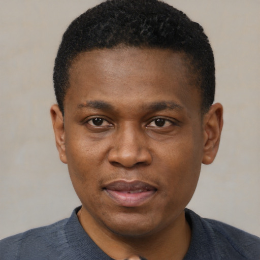 Joyful black young-adult male with short  black hair and brown eyes