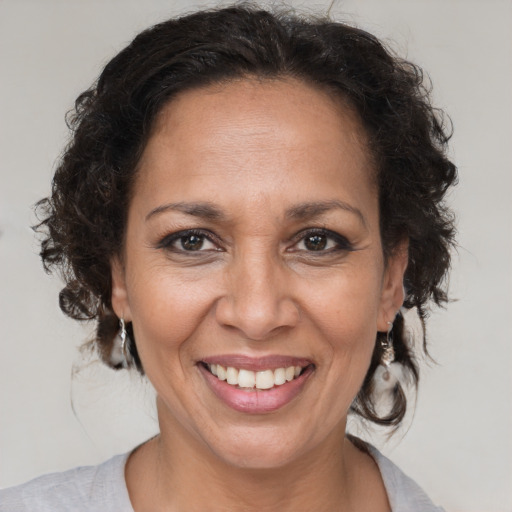 Joyful black adult female with medium  brown hair and brown eyes