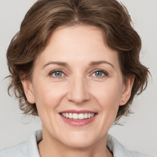 Joyful white adult female with medium  brown hair and grey eyes