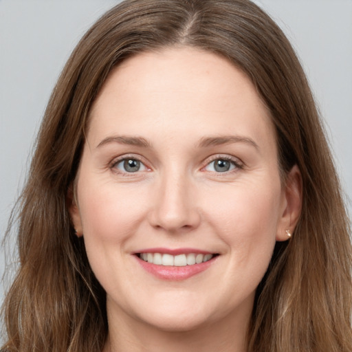 Joyful white young-adult female with long  brown hair and grey eyes