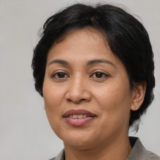 Joyful latino adult female with short  brown hair and brown eyes