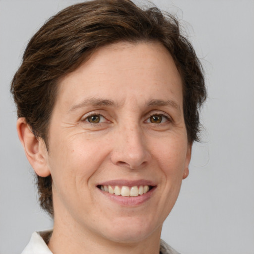 Joyful white adult female with medium  brown hair and green eyes