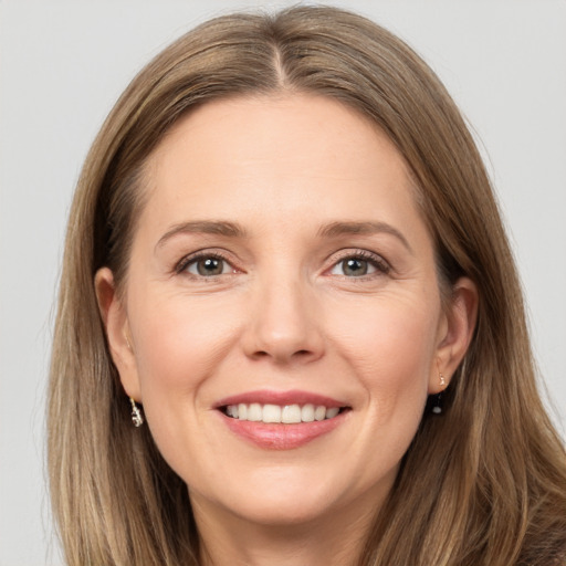 Joyful white adult female with long  brown hair and grey eyes