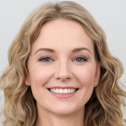 Joyful white young-adult female with long  brown hair and blue eyes