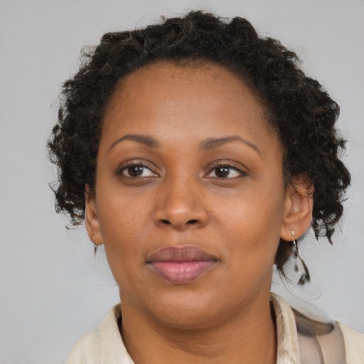 Joyful black adult female with medium  brown hair and brown eyes