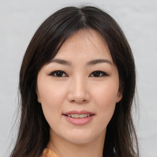 Joyful asian young-adult female with long  brown hair and brown eyes