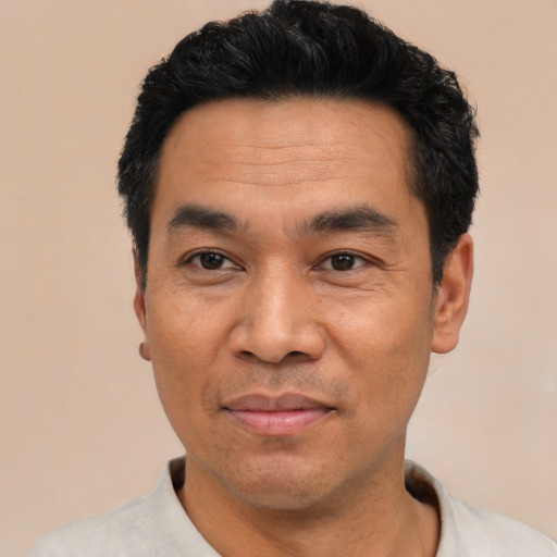 Joyful asian adult male with short  black hair and brown eyes