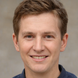 Joyful white adult male with short  brown hair and grey eyes