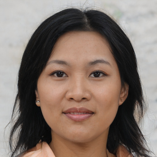 Joyful asian adult female with medium  black hair and brown eyes