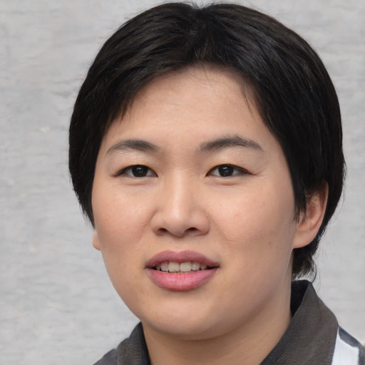 Joyful asian young-adult female with medium  black hair and brown eyes