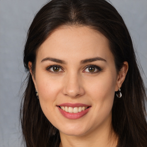 Joyful white young-adult female with long  brown hair and brown eyes