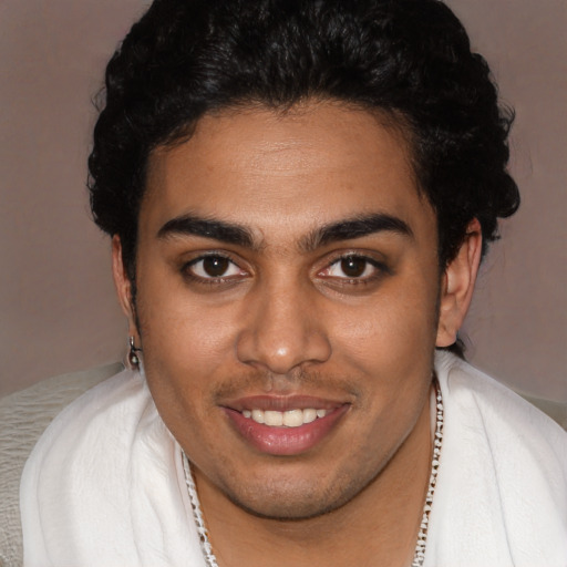 Joyful latino young-adult male with short  brown hair and brown eyes