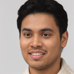 Joyful latino young-adult male with short  black hair and brown eyes