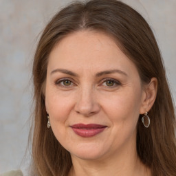 Joyful white adult female with long  brown hair and grey eyes