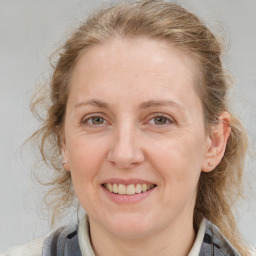 Joyful white adult female with medium  brown hair and blue eyes