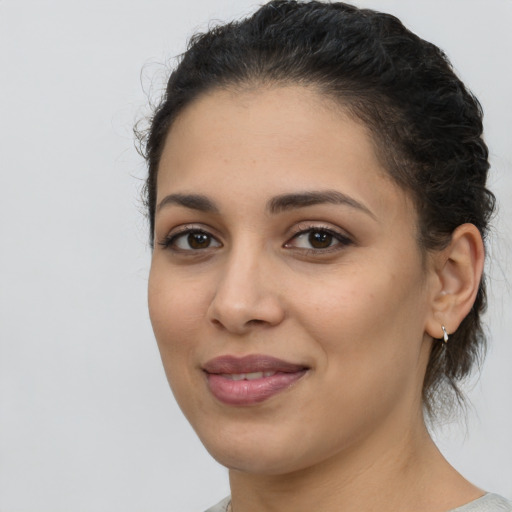 Joyful latino young-adult female with medium  brown hair and brown eyes