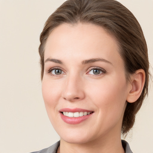 Joyful white young-adult female with medium  brown hair and grey eyes