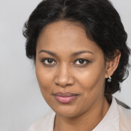 Joyful black adult female with medium  brown hair and brown eyes