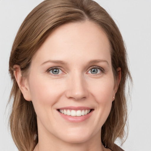 Joyful white young-adult female with medium  brown hair and grey eyes