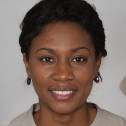 Joyful black young-adult female with short  black hair and brown eyes