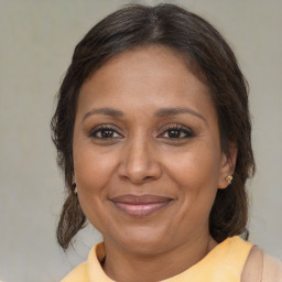 Joyful black adult female with medium  brown hair and brown eyes