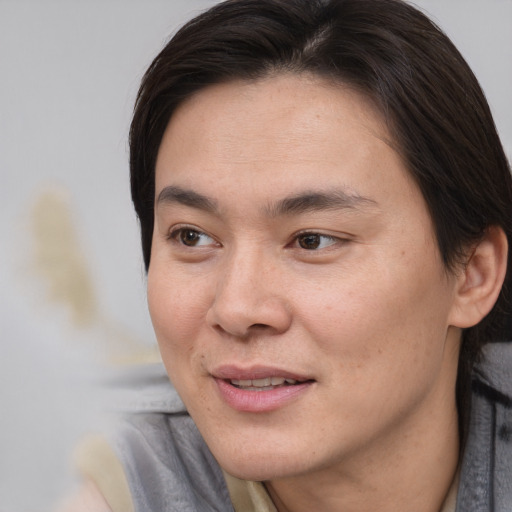 Joyful asian young-adult female with short  brown hair and brown eyes
