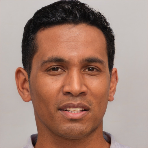 Joyful latino young-adult male with short  black hair and brown eyes