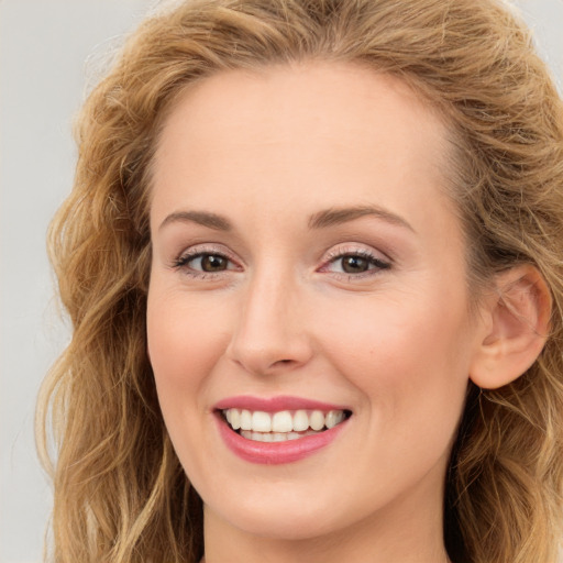 Joyful white young-adult female with long  brown hair and green eyes