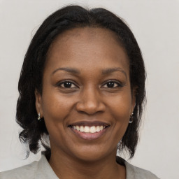 Joyful black young-adult female with medium  brown hair and brown eyes