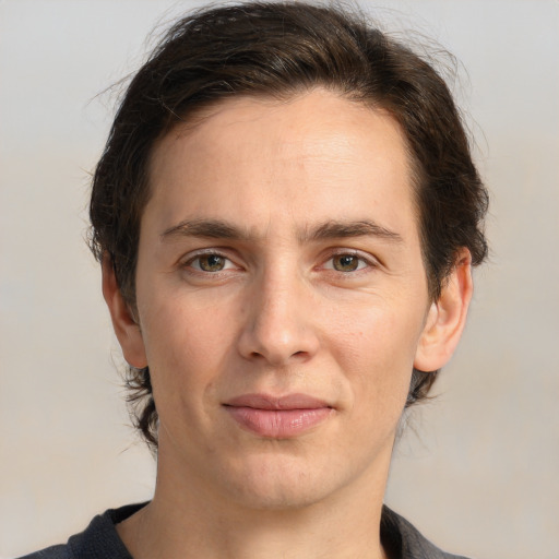 Joyful white young-adult male with medium  brown hair and grey eyes