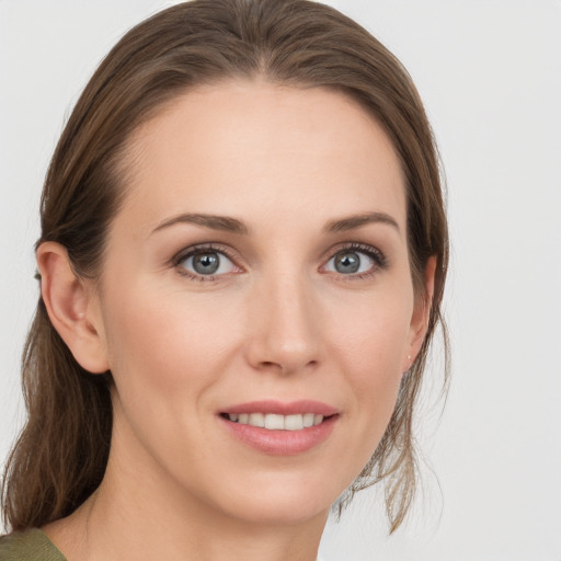 Joyful white young-adult female with medium  brown hair and grey eyes