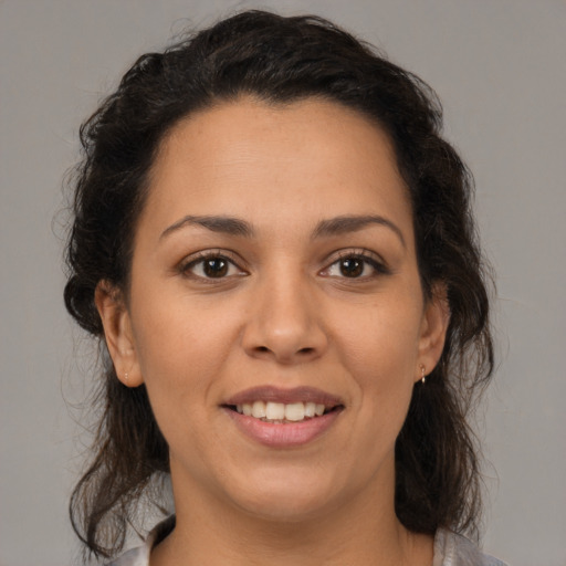 Joyful latino young-adult female with medium  brown hair and brown eyes