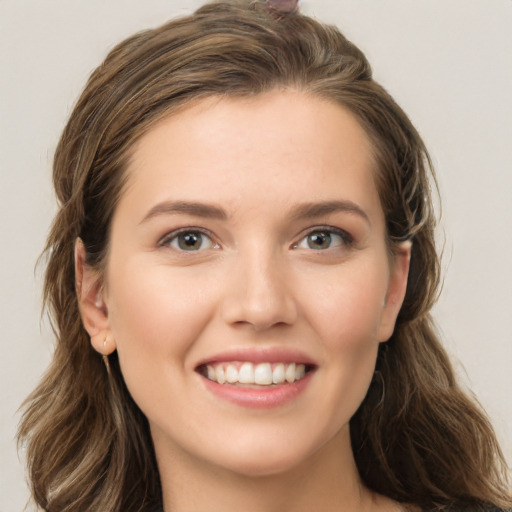 Joyful white young-adult female with long  brown hair and green eyes