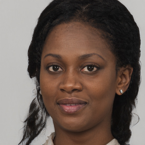Joyful black young-adult female with long  black hair and brown eyes