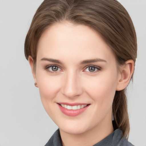 Joyful white young-adult female with medium  brown hair and grey eyes