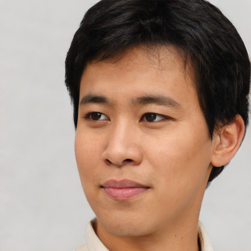 Joyful asian young-adult male with short  brown hair and brown eyes