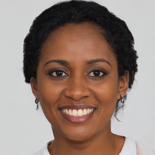 Joyful black young-adult female with short  black hair and brown eyes