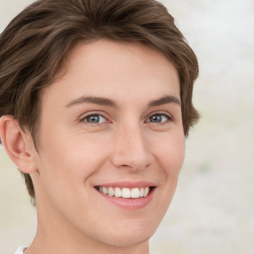 Joyful white young-adult female with short  brown hair and green eyes