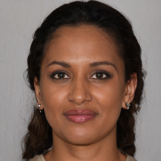 Joyful black young-adult female with medium  brown hair and brown eyes