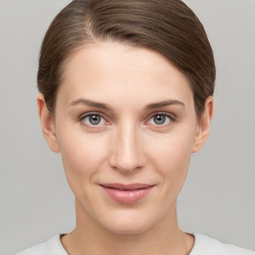 Joyful white young-adult female with short  brown hair and grey eyes