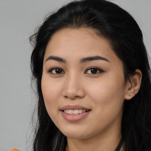 Joyful latino young-adult female with long  black hair and brown eyes