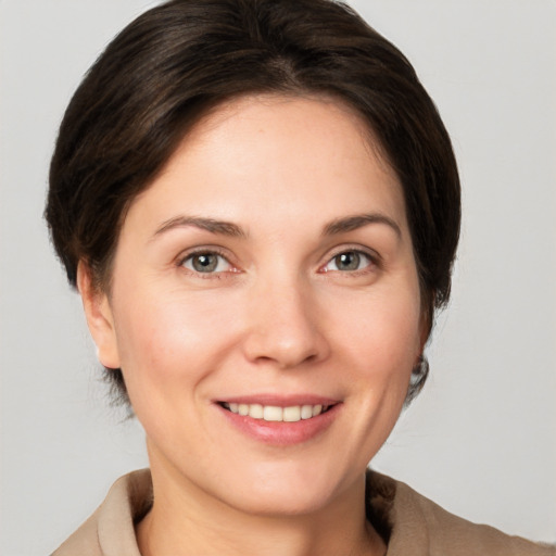 Joyful white young-adult female with short  brown hair and grey eyes