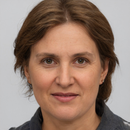 Joyful white adult female with medium  brown hair and grey eyes