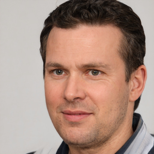 Joyful white adult male with short  brown hair and brown eyes