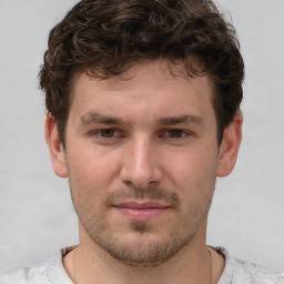 Joyful white young-adult male with short  brown hair and grey eyes