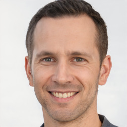 Joyful white adult male with short  brown hair and brown eyes