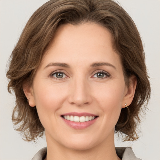 Joyful white young-adult female with medium  brown hair and grey eyes